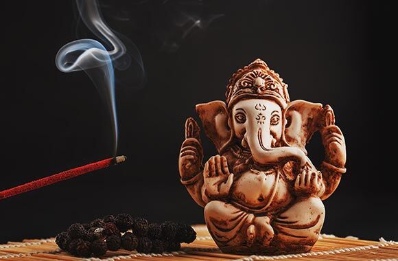 Ganesha Figur neben Räucherstäbchen