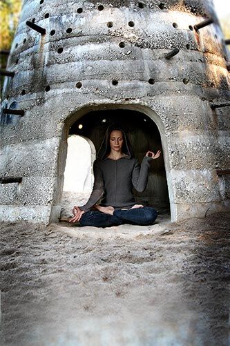 JNANA MUDRA Frau sitzt in einem kleinen Turm im Sand und formt mit ihren Händen das Jnana Mudra