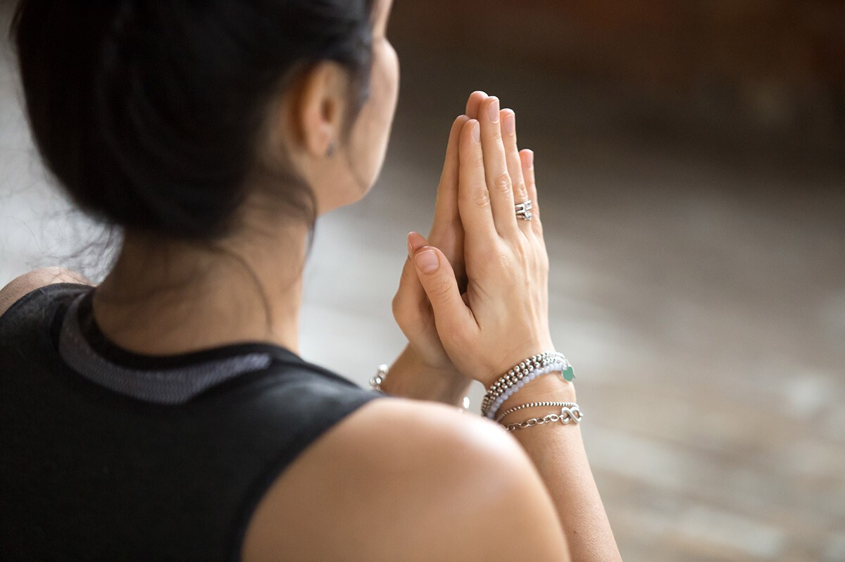 Mudra Frau macht Yoga, ihren mit Accesoires behängten Hände formt sie eine Mudra