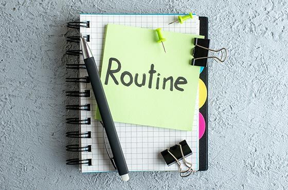 Notizblock mit Stift und Post-it "Routine"