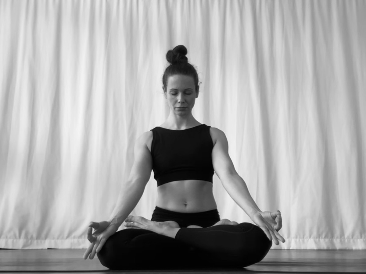Deine 15 Minuten Me Time, Yogi sitzt im Lotussitz, formt Mudras mit den Händen und meditiert