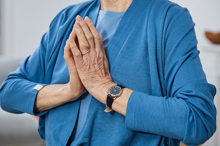 yogafueralle_OMY_telefonyoga 2 Eine alte Dame hat ihre Hände zu einer Mudra geftormt