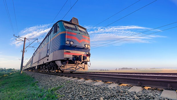 Im Urlaub mit der Bahn verreisen Im Urlaub mit der Bahn verreisen, eine Bahn fährt auf den Gleisen in einer schönen Landschaft, der Himmel ist blau